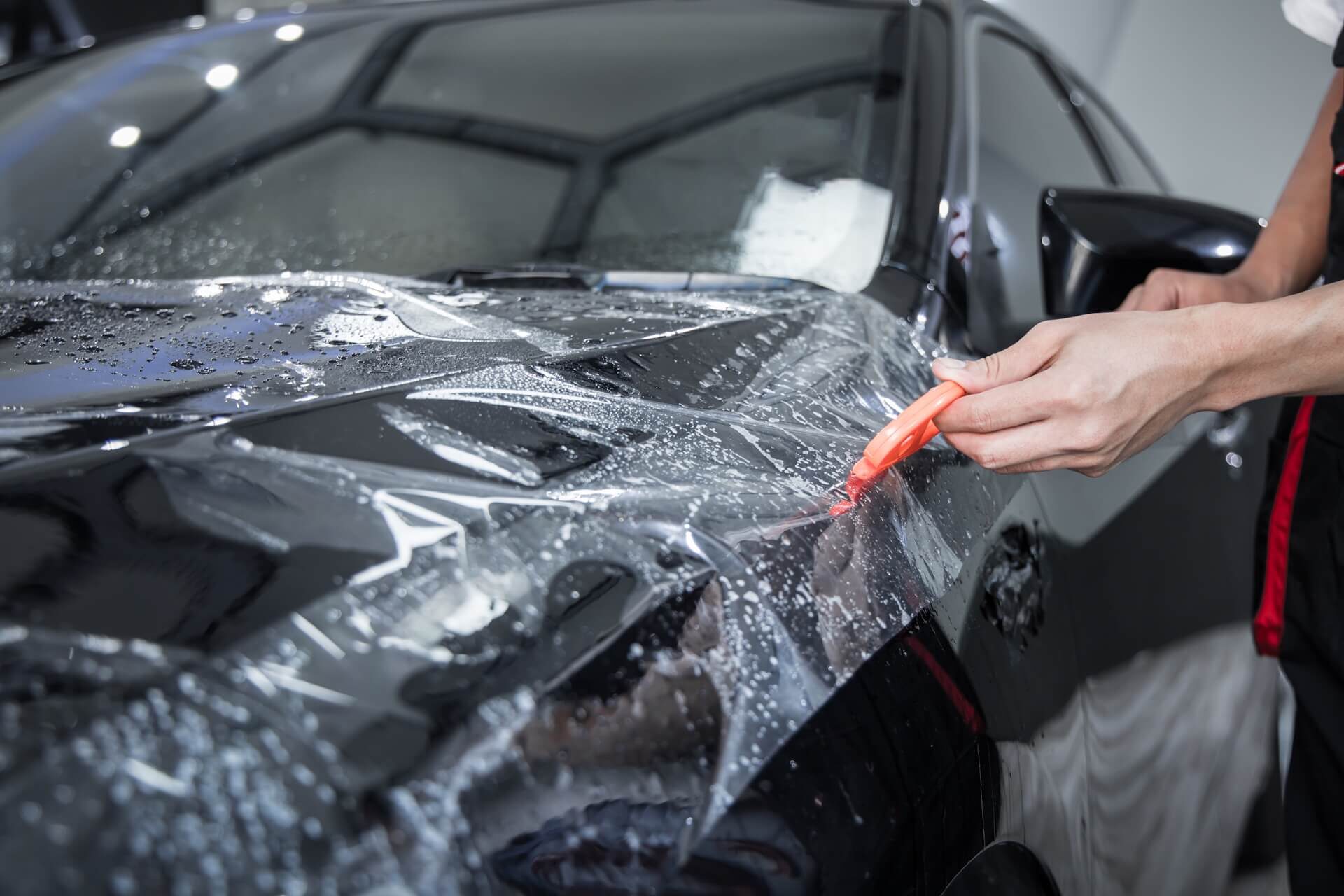 Technician applying paint protection film (PPF)