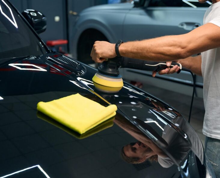 Technician applying ceramic coating to sports car